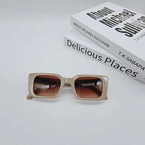 Close-up of retro rectangular sunglasses with beige frames and brown gradient lenses