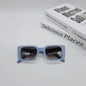 Close-up of light blue rectangular sunglasses with matte frame and gradient lenses