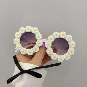 Detail of round children sunglasses with 3D white daisy flowers and purple gradient lenses