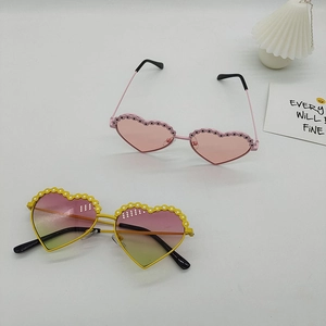 Lunettes de soleil coeur enfant avec pois roses et motifs fleurs jaunes sur fond blanc