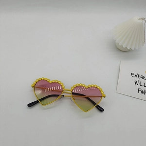 Gros plan sur des lunettes de soleil en cœur avec monture jaune et verres dégradés