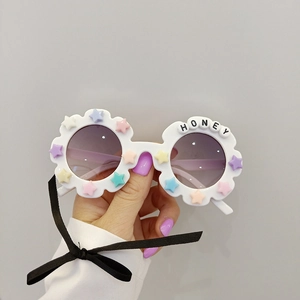 Detail of flower-shaped kids sunglasses with HONEY beads and colorful star accents