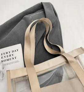 Dettaglio dei robusti manici in nylon beige su una borsa mare trasparente in PVC