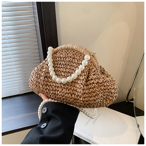 Détail d'une pochette en paille tissée main avec poignée en perles et bandoulière perle
