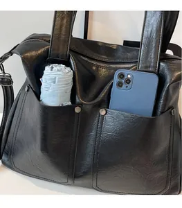 Detail of black vintage tote bag with metal studs showing spacious interior capacity