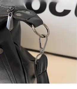Macro detail of silver-tone metal hooks and zipper on black lychee texture leather bag