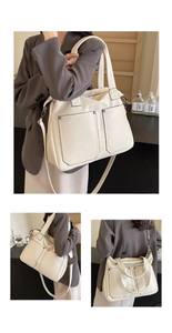 Detail of a large cream tote bag showing dual front pockets and adjustable shoulder strap