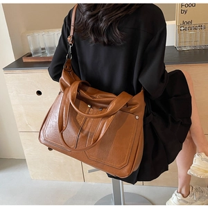 Detailed shot of brown vintage tote bag with matte leather texture and side pocket