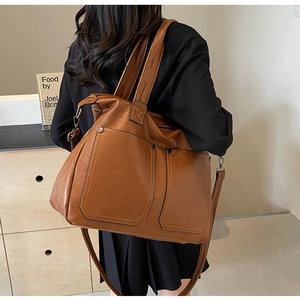 Detail of vintage brown tote bag with double front pockets and adjustable shoulder strap