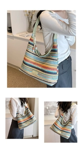 Detail of colorful striped straw tote with green faux leather strap and beaded charm