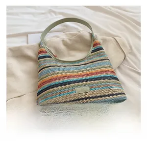 Detailed close-up of rainbow striped woven tote bag with textured knit fabric and green handle