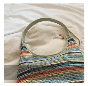 Detail of colorful rainbow striped woven tote bag with smooth green shoulder straps