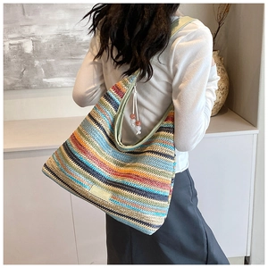 Detail of bohemian rainbow striped woven tote bag with bead tassel and logo patch
