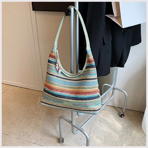 Detail of colorful rainbow woven tote with light green strap and pink bead zipper pull