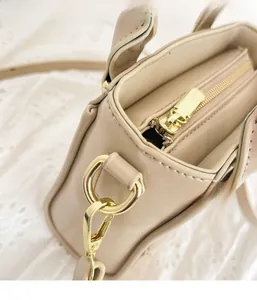 Détail de la fermeture éclair et des finitions dorées sur ce sac beige chic