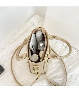 Vue intérieure du sac seau beige montrant sa grande capacité pour téléphone et cosmétiques