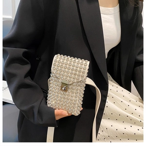 Dettaglio mini borsa a tracolla con strass argento e cinturino in pelle bianca
