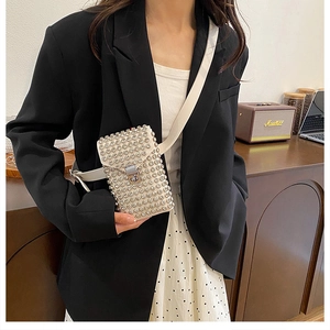 Dettaglio mini borsa in pelle bianca con borchie argentate e chiusura a scatto in metallo