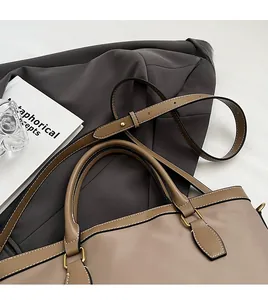 Close-up of earth-tone tote bag with gold hardware on a dark grey suit jacket