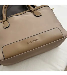 Detailed macro view of CLEAROK brand logo embossed on khaki nylon and leather fabric