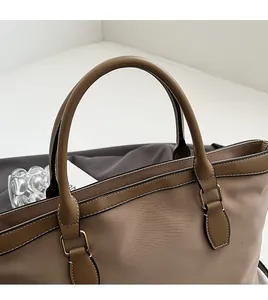 Detail of durable handles and stitching on this large taupe nylon commuter tote bag