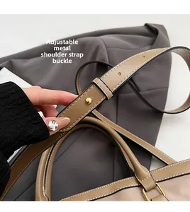 Detail of adjustable PU leather shoulder strap with golden metal buckle and white stitching