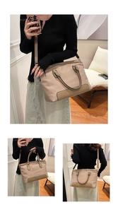 Detail of beige nylon tote bag with black trim handles and CLEANQX logo on brown leather base