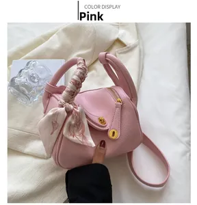 Détail du sac Boston en cuir grainé rose avec foulard en soie et finitions dorées
