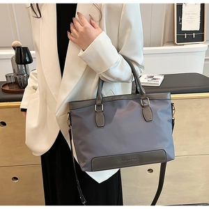 Detail of grey-blue tote bag showing CLEARON logo and premium leather trim details