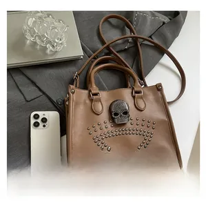 Close-up of vintage brown tote bag featuring a diamond skull and silver stud details