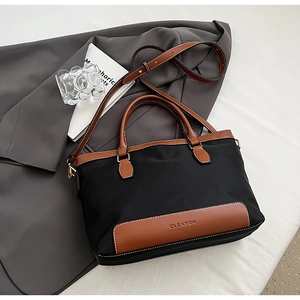 Détail du sac cabas en nylon noir avec bordures en cuir et logo de marque CLEAROK
