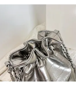 Detail of silver metallic bucket bag with soft pleated texture and chain strap