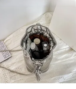 Top view of silver drawstring bucket bag showing spacious interior with phone and cosmetics