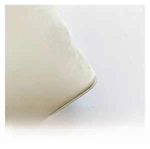 Close-up of the smooth beige PU leather texture and rounded corner of the shoulder bag