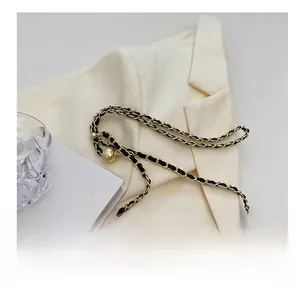 Détail de la bandoulière en chaîne dorée avec cuir noir et boucle boule ajustable
