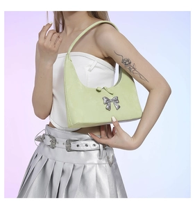 Close-up of avocado green faux leather hobo bag with a silver metallic bow detail