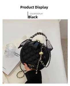 Détail du sac rond noir matelassé avec chaîne dorée et poignée en foulard de soie