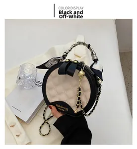 Détail de couture matelassée sur sac à main rond bicolore avec poignée en foulard