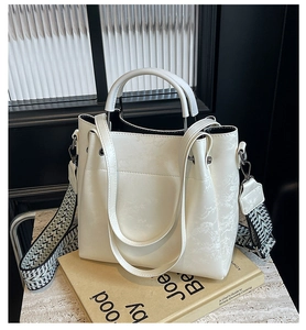 Détail du sac en cuir crème gaufré feuilles de bambou avec large bandoulière ethnique