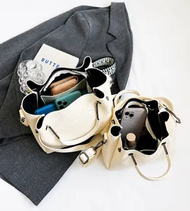 Vista interior del bolso tote crema de gran capacidad con bolsillos y artículos diarios