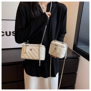 Detail of white quilted chain bags featuring silver flower accents and elegant chain straps