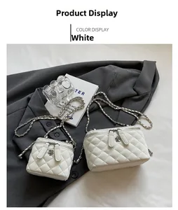 Close-up of quilted white chain bags with flower zipper pull and silver hardware details