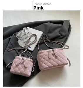 Close-up of pink quilted chain bags with metal flower zipper details on grey suit