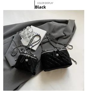 Detail view of black quilted crossbody bags with silver floral zipper pulls and chain strap