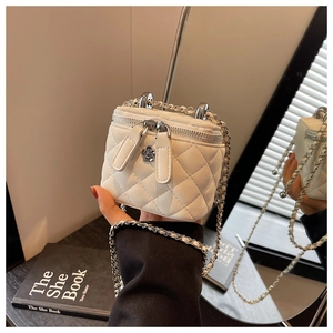 Detailaufnahme der weißen gesteppten Mini-Box-Tasche mit Kamelien-Reißverschluss und Kettenriemen