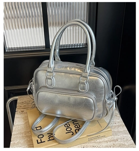 Detail of silver metallic leather handbag with wrinkled texture and dual zippers