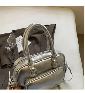 Detail of silver boston bag featuring retro wrinkled texture and sturdy handles