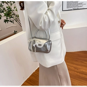 Close-up of silver PU leather crossbody bag with pearl bow and heart charm details