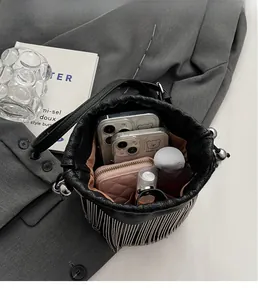 Innenansicht der schwarzen Beuteltasche mit viel Platz für Handys und ein rosa Portemonnaie