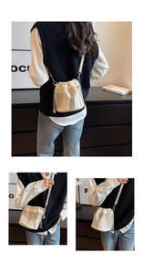 Detailansicht einer weißen Beuteltasche mit eleganten silbernen Kettenquasten und Kordelzug